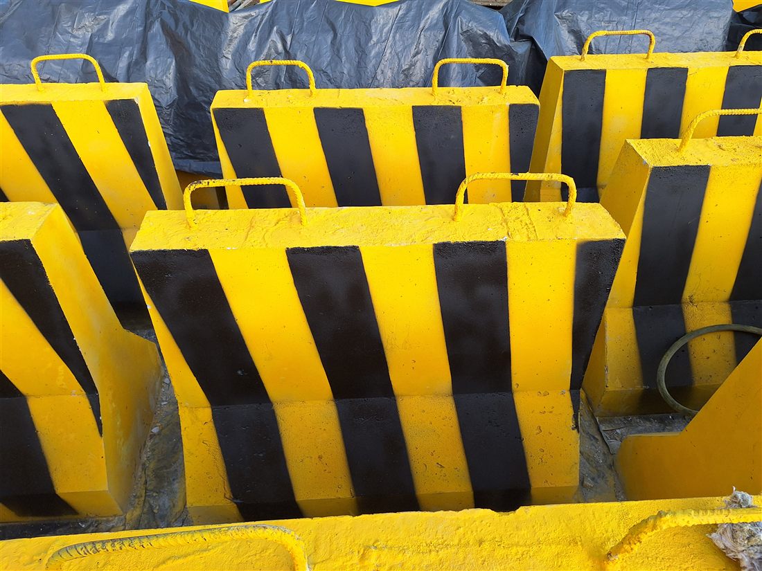 Detalhe das barreiras de concreto JWS com pintura amarela e faixas pretas