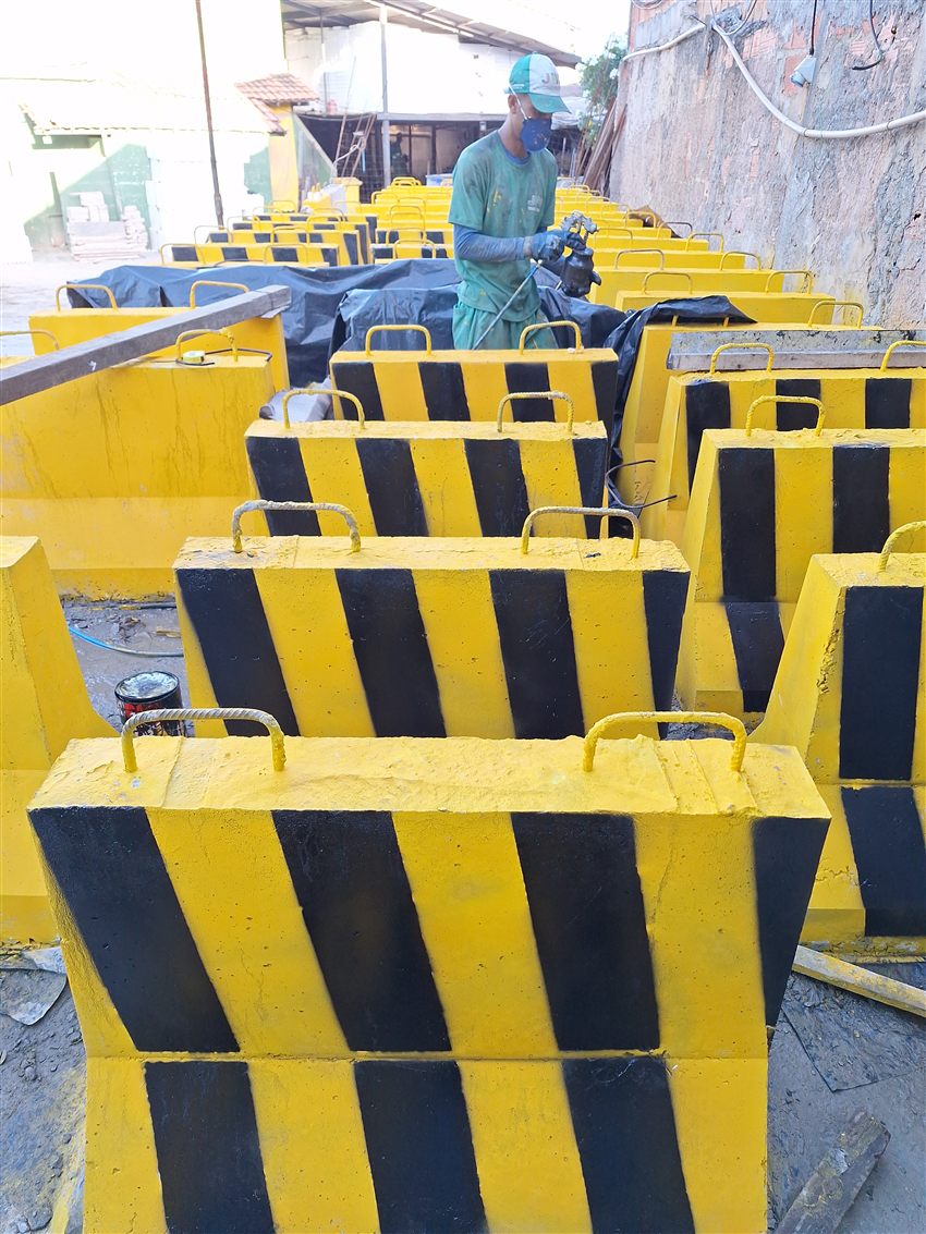 Profissional da JWS durante o acabamento de barreiras de concreto na fábrica